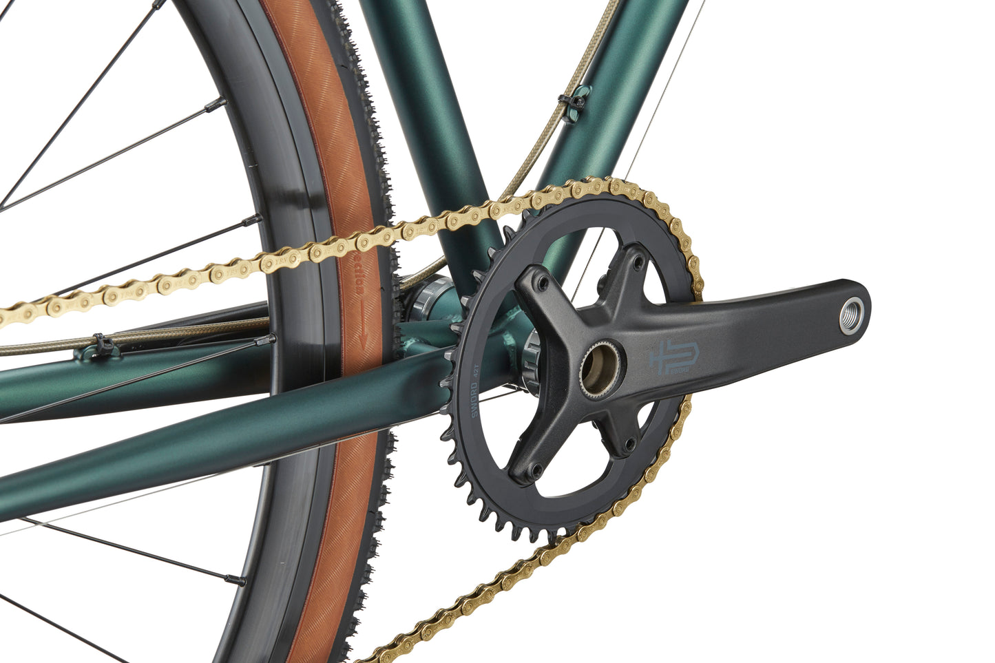 Close-up of CATALINA 2’s chromoly crankset, gold chain, and chainring on a green frame with tan-wall tires—urban-ready style.
