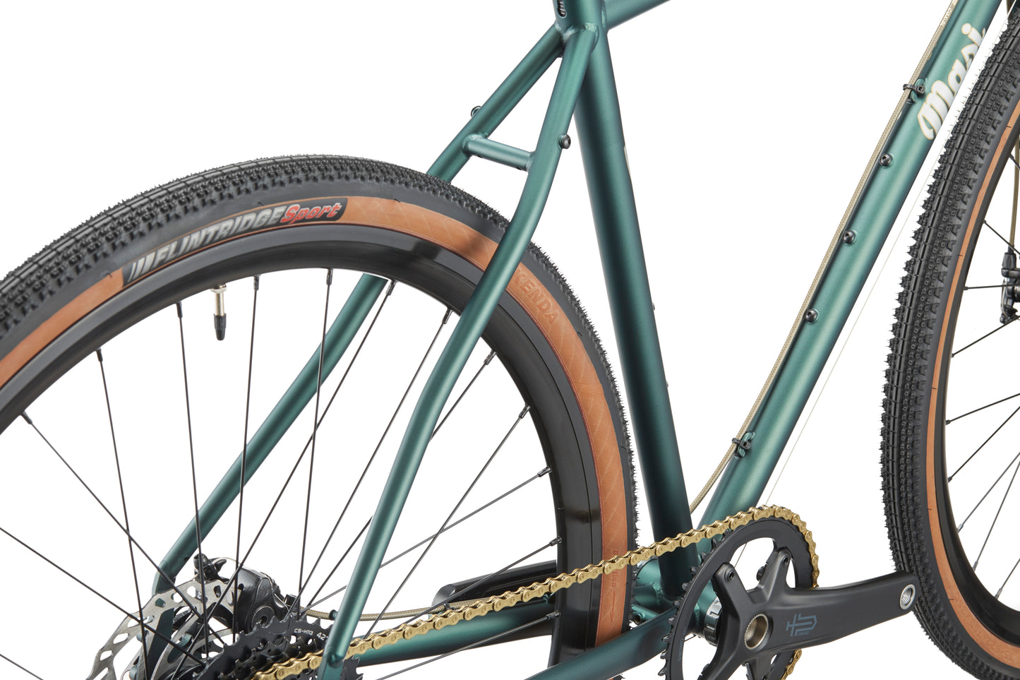 Close-up of the CATALINA 2: green chromoly steel frame, tan-walled tires, black spokes, and a gold chain—built for the city.