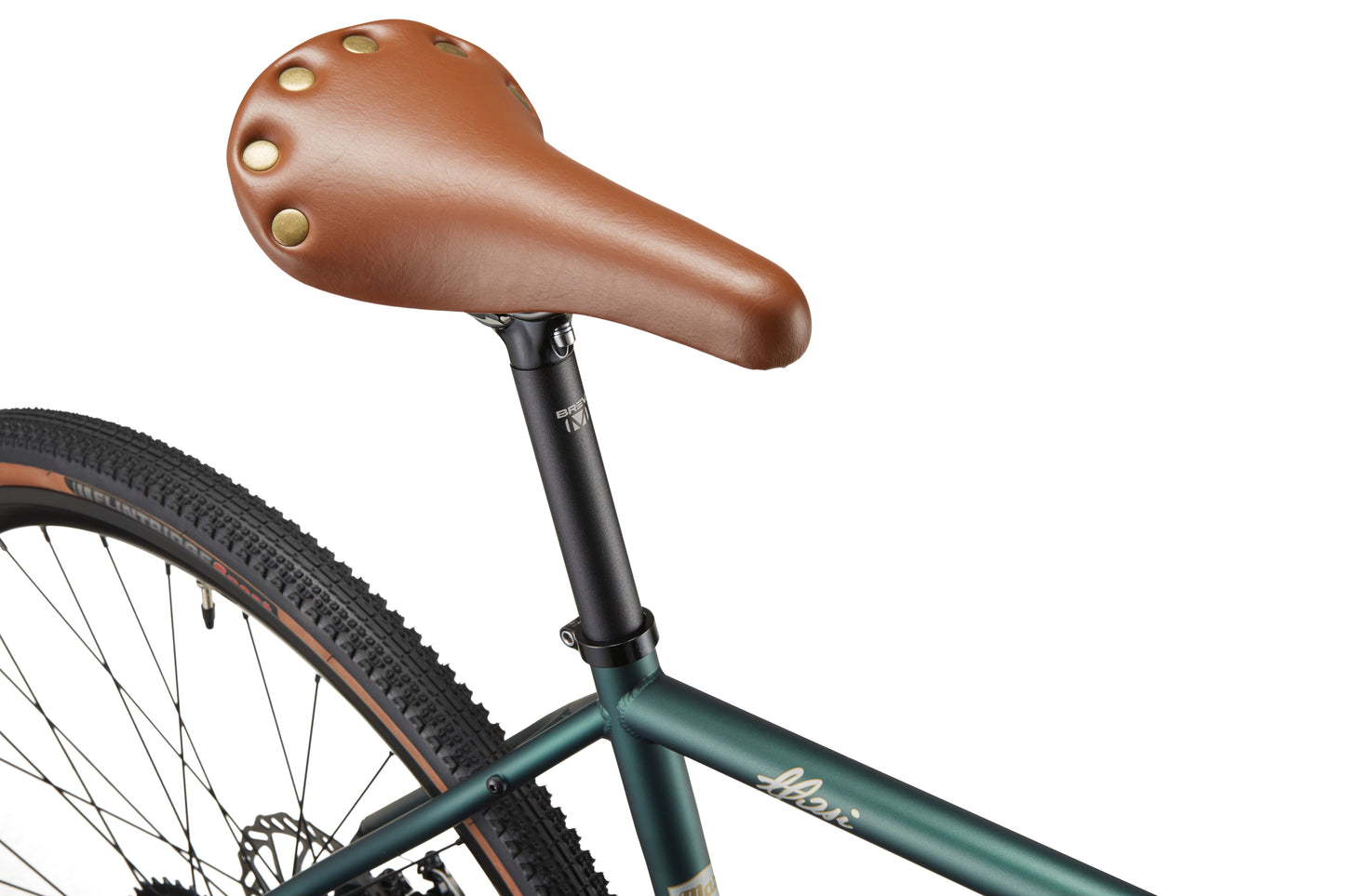 Close-up of the CATALINA 2 brown leather seat with brass rivets on a green chromoly steel bike, showing urban appeal.