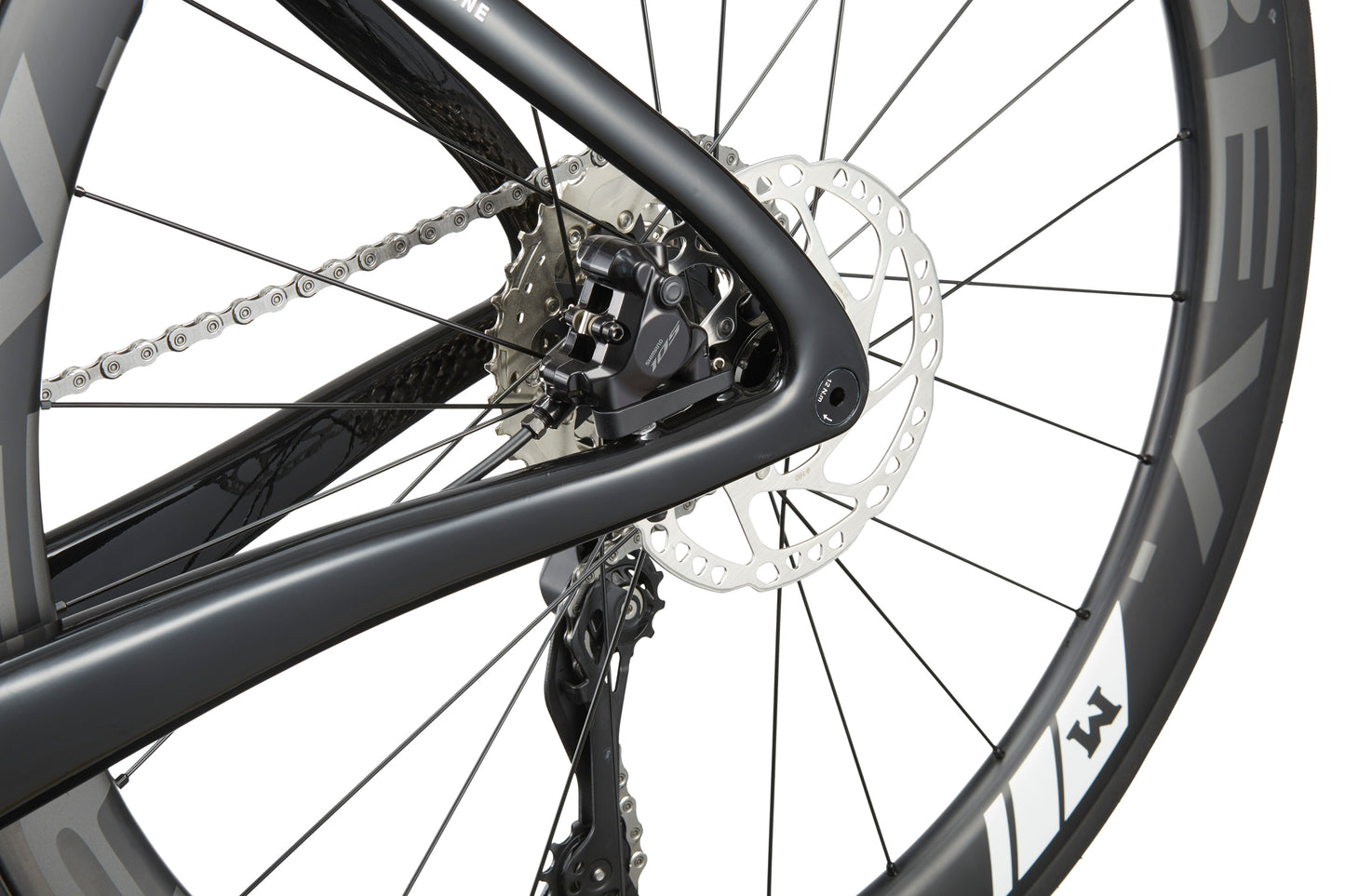 Close-up of EVOLUZIONE 1 racing bikes rear wheel, highlighting the disc brake, chain, and frame in a sleek aerodynamic design.