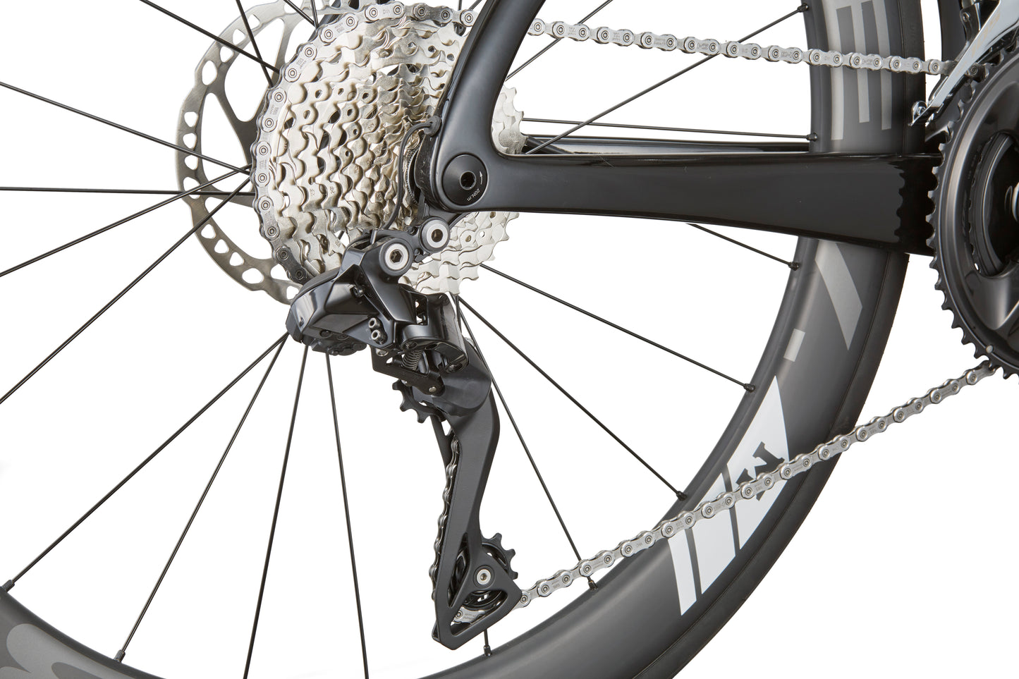 Close-up of the EVOLUZIONE 1 rear derailleur and gear cassette featuring an aerodynamic design with a black frame and gray wheel spokes.
