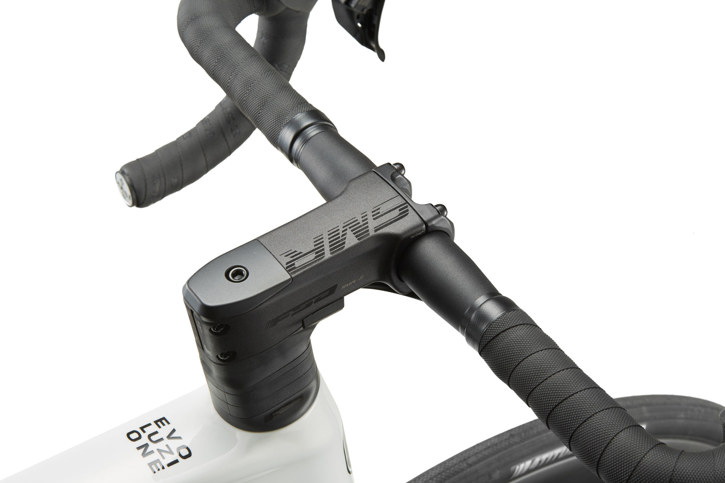 Close-up of EVOLUZIONE 1s carbon bike black handlebars and stem with textured grip on a white frame; brand name is visible.