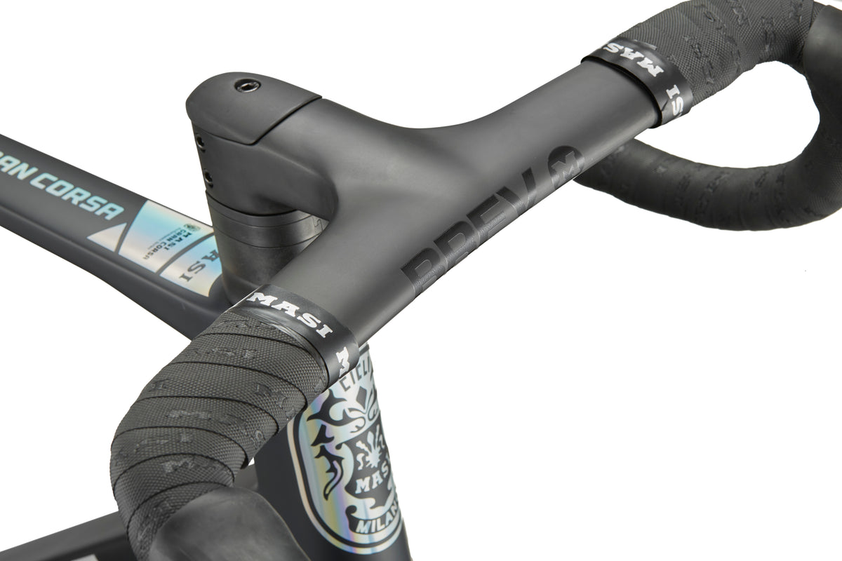 Close-up of the GRAN CORSA matte black carbon handlebar and stem, featuring Masi logo and textured bar tape.