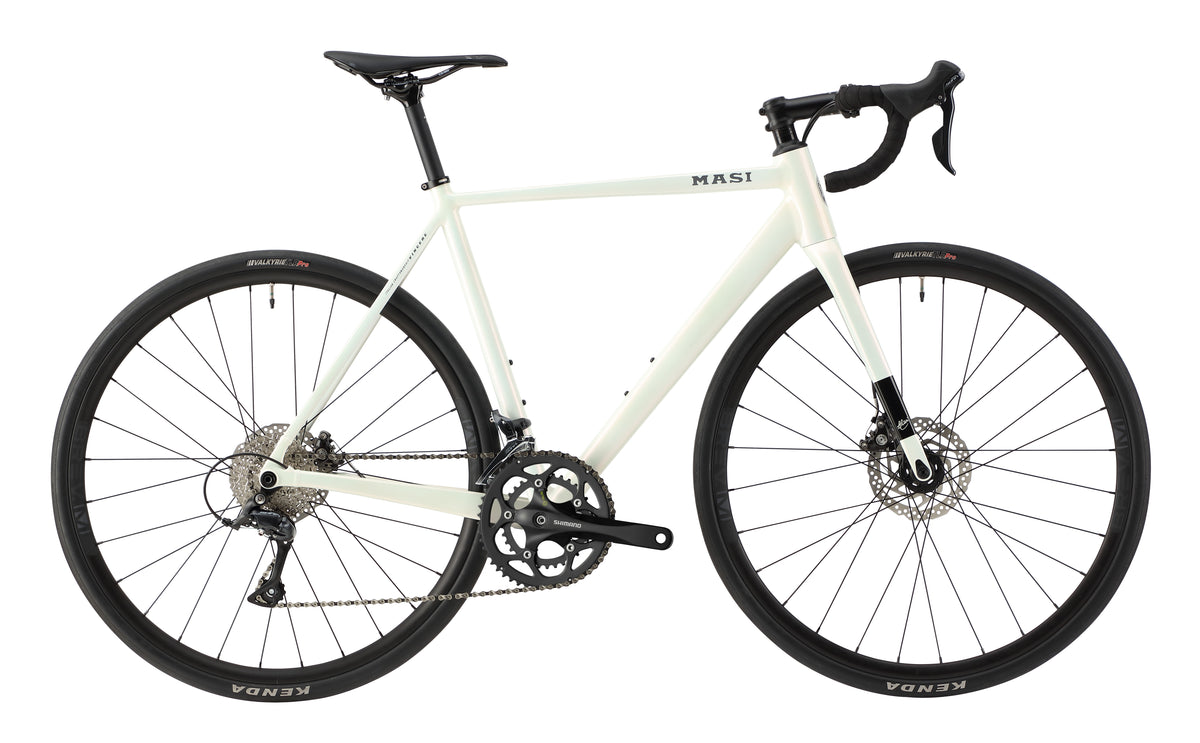 The sleek white VINCERE 4 racing bike boasts a streamlined alloy frame, drop handlebars, disc brakes, and black tires with visible gears.