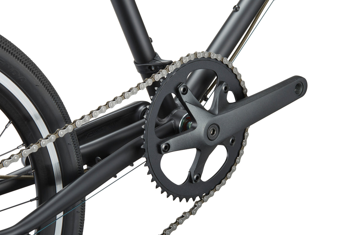 Close-up of the STELVIO 3 MiniVelo crankset, chainring, and chain exudes urban sophistication on a white background.