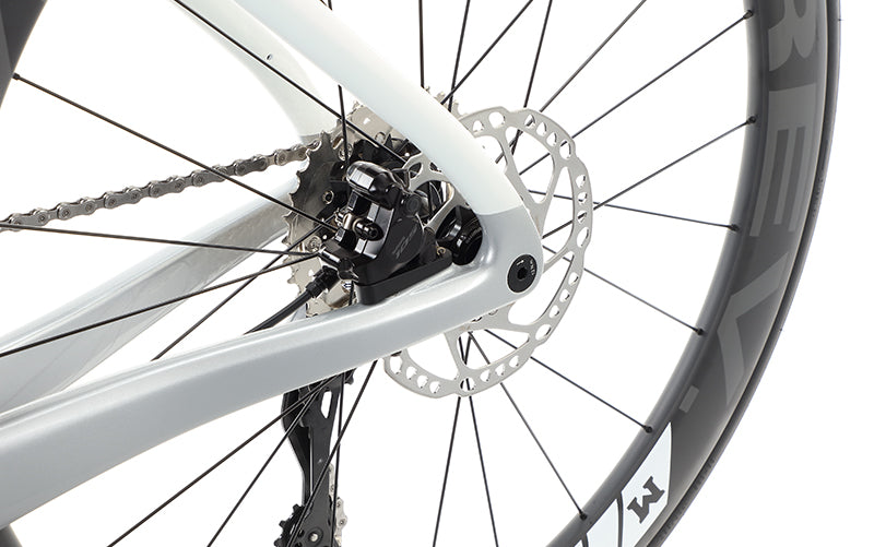 Close-up of the Masi Bikes EVOLUZIONE 1s rear wheel and gear system, showcasing an aerodynamic design with a disc brake and black spokes, highlighting the road bikes mechanical details and sporty features.