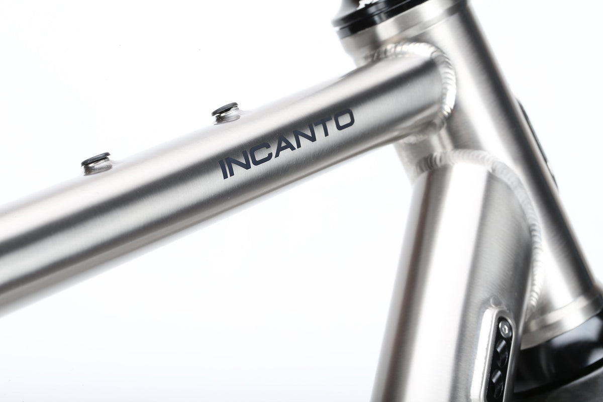 A close-up of the INCANTO Ti FRAMESET by Masi Bikes showcases INCANTO on the top tube. The 3AL/2.5V titanium tubing and clean welds create a sleek, modern look against a plain white background, reflecting an ideal blend for gravel bike adventures.