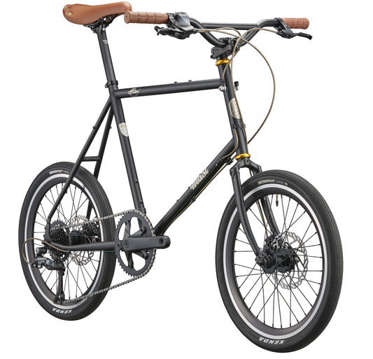 The black STELVIO 3 MiniVelo city bike features brown handlebars and seat, small wheels, and disc brakes on a white background.