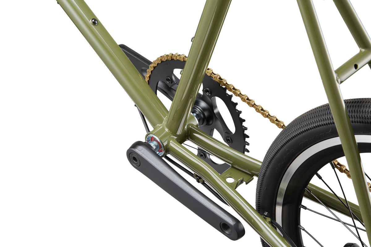 Close-up of the STELVIO 2 green MiniVelo frame, chain, pedals, and rear tire against a white background.