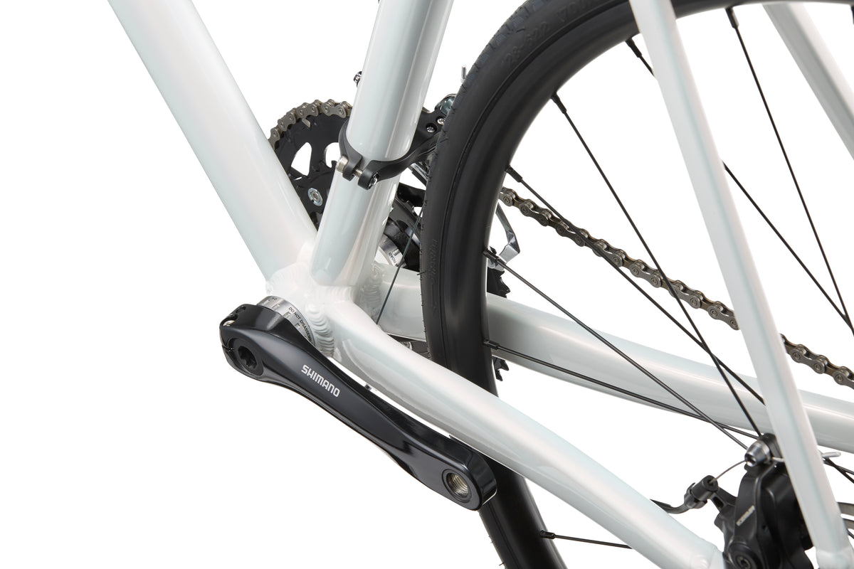 Close-up of the VINCERE 3s gear and chain system featuring a Shimano Tiagra crankset, rear wheel, and part of the sleek alloy frame.