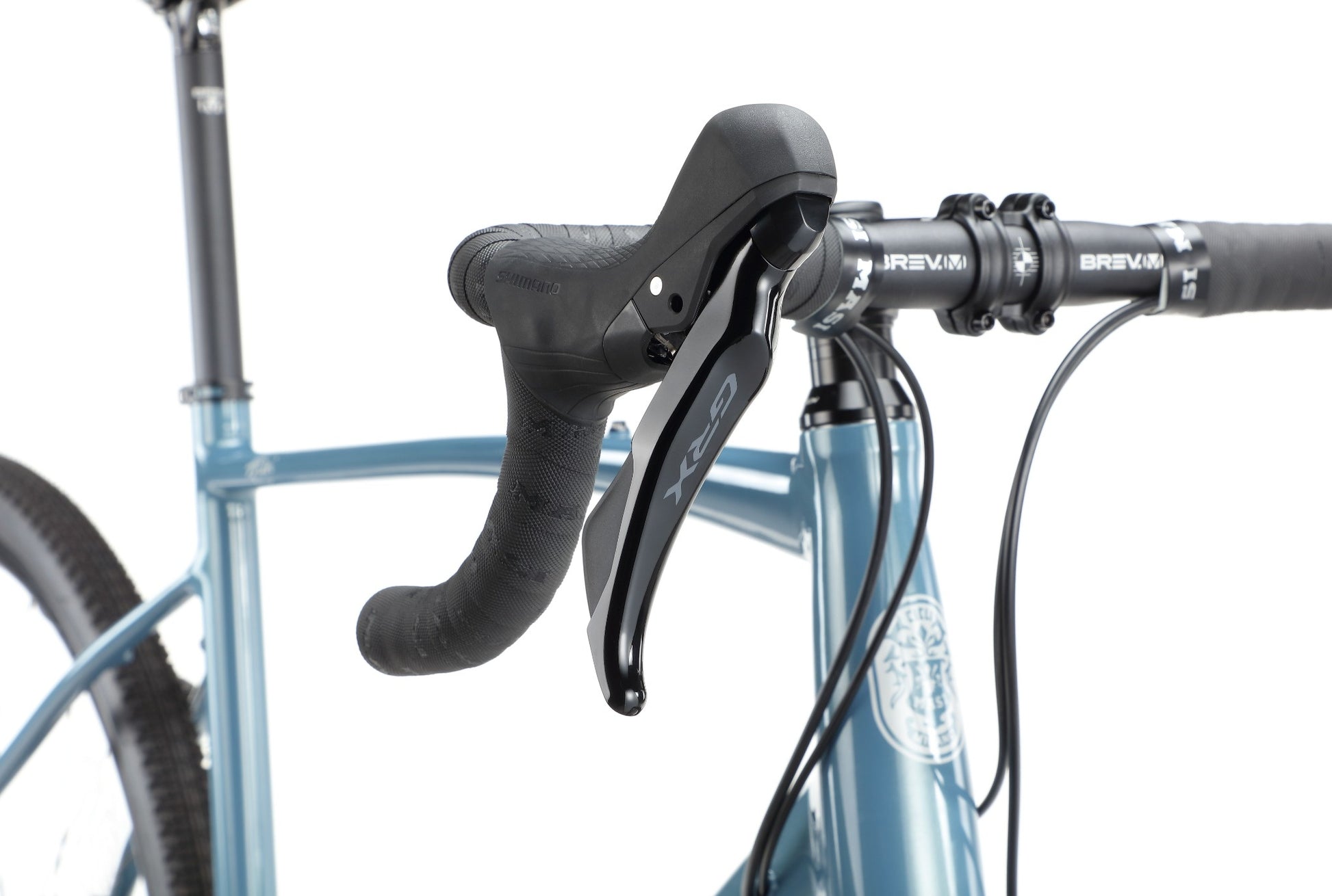 Close-up of BRUNELLO 1’s black handlebar and gear shifter on a lightweight alloy frame, against a white background.