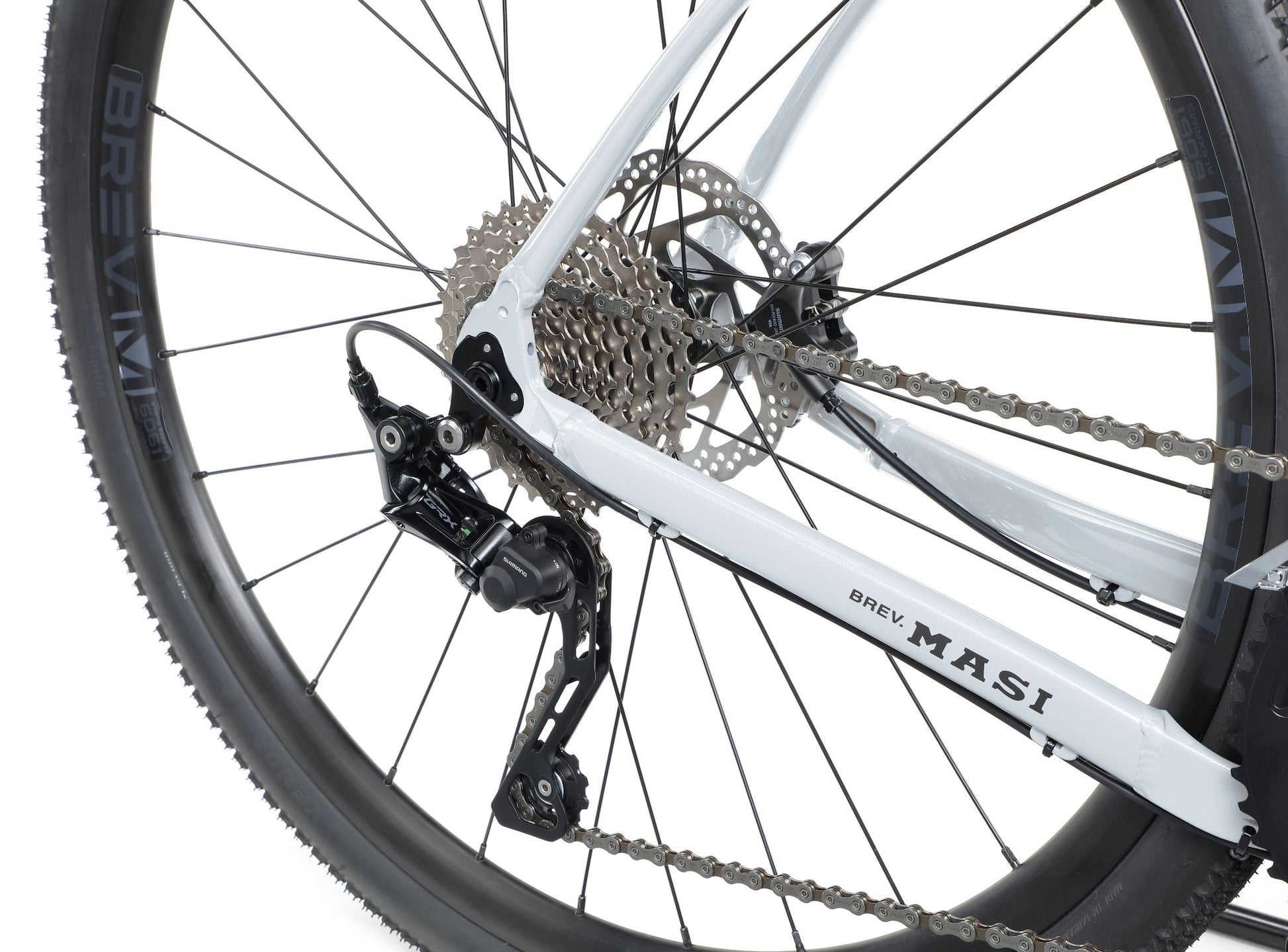 Close-up of BRUNELLO 1’s rear wheel, showing gears, disc brake, and white lightweight alloy frame.