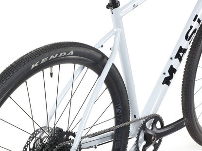 Close-up of BRUNELLO 3s lightweight alloy frame, rear tubeless-ready KENDA tire, chain, and crankset on white background.