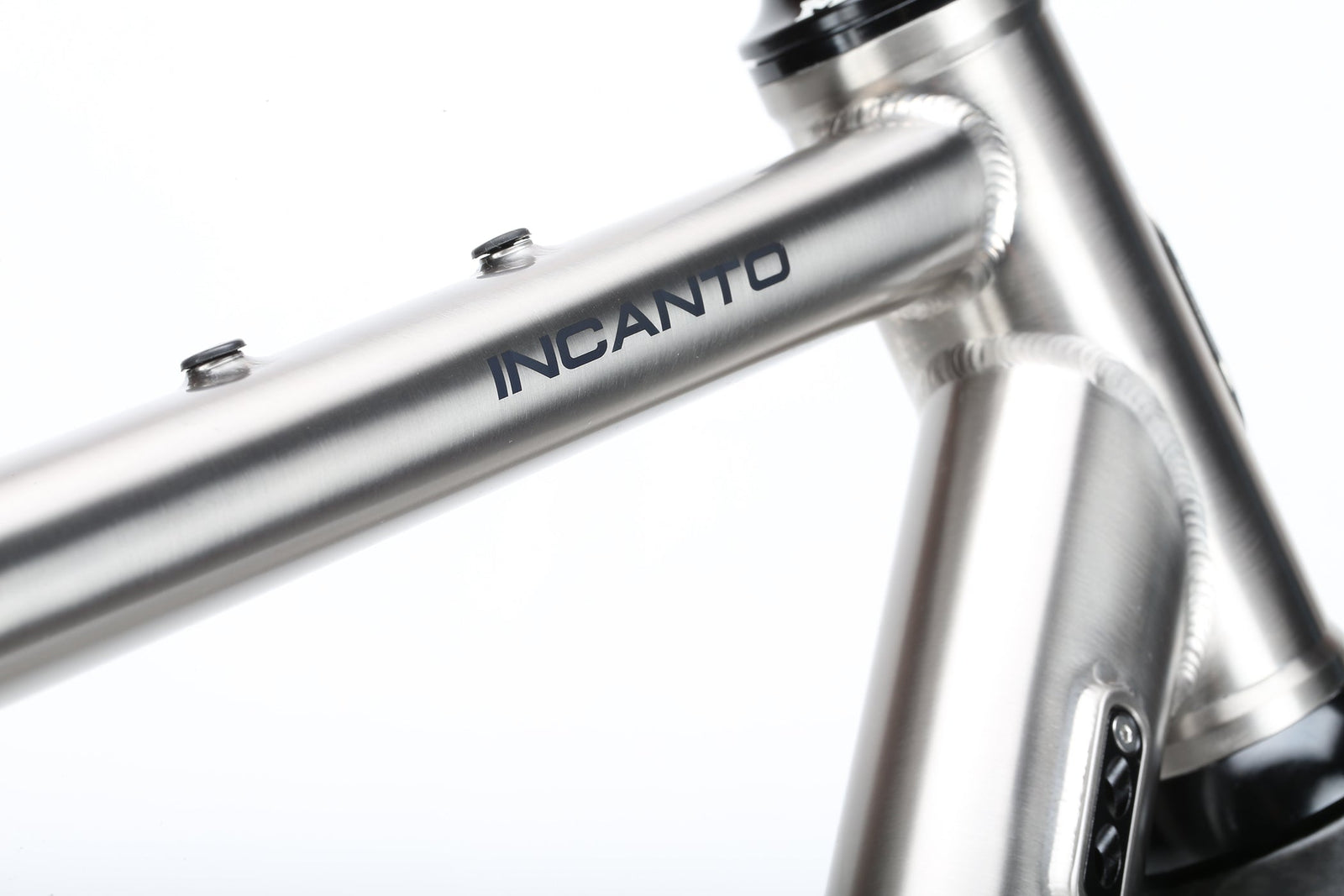 A close-up of the INCANTO Ti FRAMESET by Masi Bikes showcases INCANTO on the top tube. The 3AL/2.5V titanium tubing and clean welds create a sleek, modern look against a plain white background, reflecting an ideal blend for gravel bike adventures.
